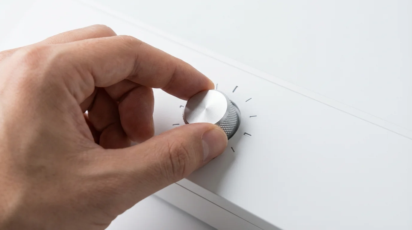 Hand adjusting a dial on a control panel, symbolising setting personal deposit limits